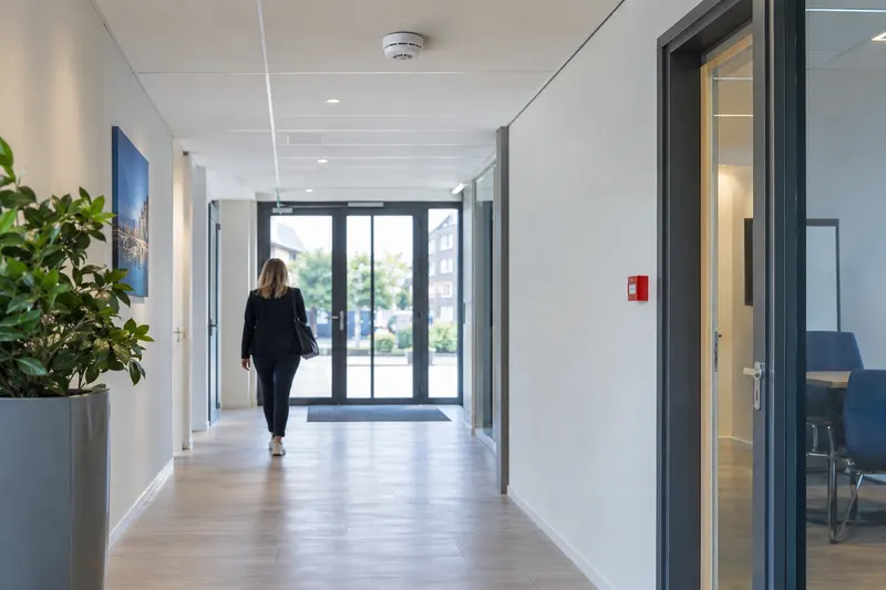 Gang in een bedrijfspand met een rookmelder en handmelder